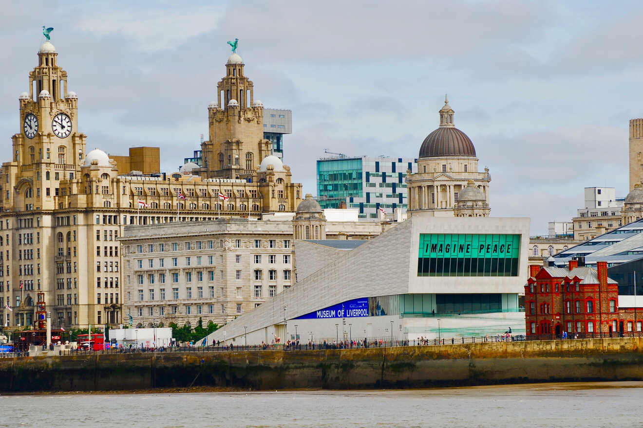 Liverpool's waterfront with the Museum of Liverpool and the iconic Royal Liver Building, under a cloudy sky with the message 'Imagine Peace' featured prominently